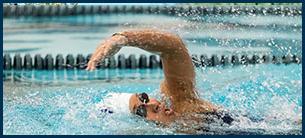 a woman swimming athlete in mid stroke.