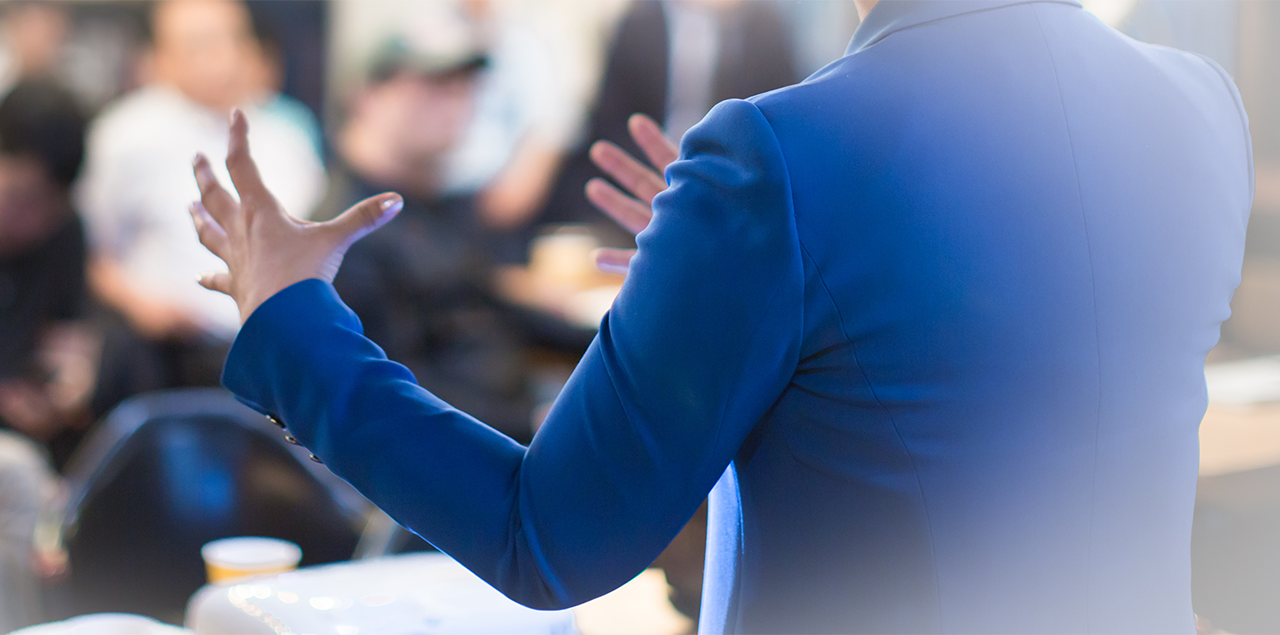 shot of a woman from behind, presenting to a crowd of people